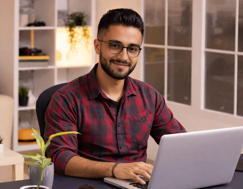 James Patel working at a laptop in a modern office